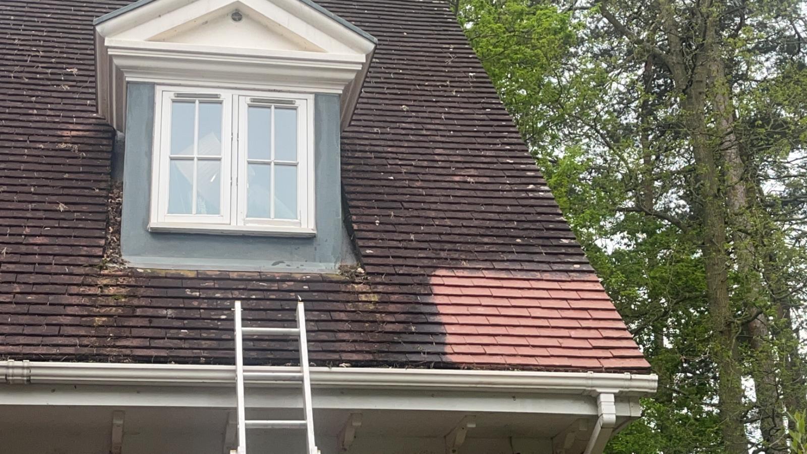 Slate roof with dormer mid-clean showing restored tile colour